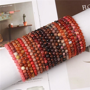 Detail of colorful 8mm natural stone elastic bracelets with engraved gold script beads