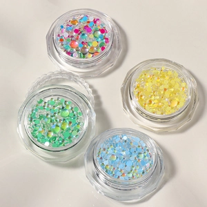 Macro shot of colorful mermaid bubble beads in jars for creative nail art design