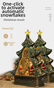 Detailed view of dual Christmas tree music boxes with spinning snow and bronze bases