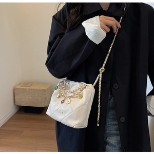 White quilted bucket bag with gold chain strap and colorful heart enamel charms
