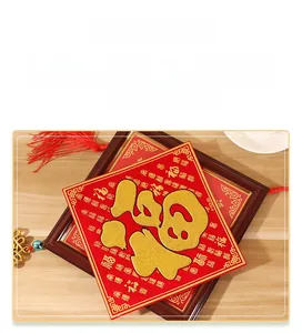 Gros plan du sticker chinois Fu du Nouvel An avec paillettes dorées et pompons rouges
