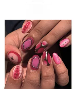 Détail d'ongles dégradés roses avec bordure métallique argentée et accents de rivets 3D