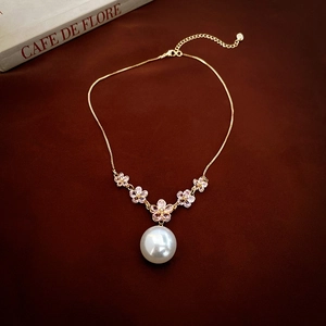 Elegant gold choker necklace with pink zircon flowers and a large white pearl drop pendant