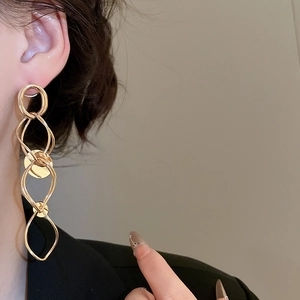 Close-up of a model wearing long golden interlaced tassel drop earrings for women