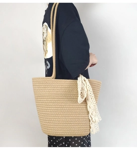 Detail of khaki cotton rope woven tote bag with lace scarf on a shoulder model
