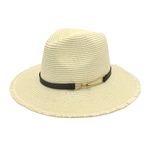 Detail of cream straw fedora with black leather band and gold buckle featuring frayed edges