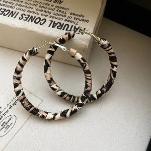 Vue détaillée de grandes créoles à motif zèbre sur un décor vintage sophistiqué