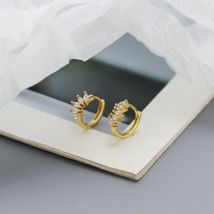 Detail of S925 gold-plated earrings with marquise zircon on a textured white card