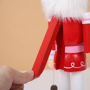 Detail view of the mechanical lever on the back of a red wooden Nutcracker soldier