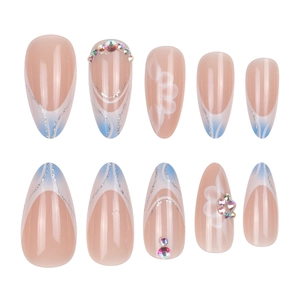 Faux ongles amande avec pointes French bleues, fleurs blanches et strass brillants