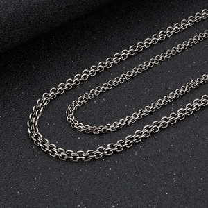 Gros plan des maillons de collier en acier inoxydable gris bronze à double verrou