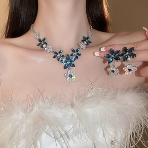 Detail of silver floral jewelry set with blue and clear zircon crystals on a model