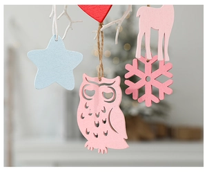 Macro focus on laser-cut wooden owl pendant and star ornaments for Christmas tree