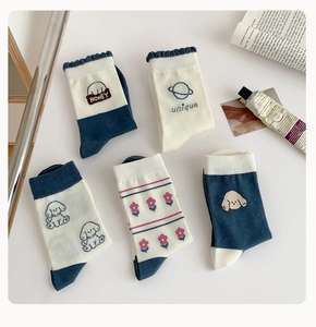 Détail de chaussettes bleues en coton avec broderie chiot et motif graphique unique