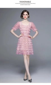 Détails des manches bouffantes en dentelle rose et volants superposés d'une robe d'été
