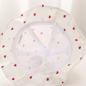 Détail du chapeau bébé blanc à cœurs rouges, doublure en maille et mentonnière
