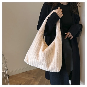 Side view of large plush beige hobo bag on model in a cozy minimalist interior