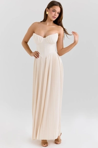 Close-up of pleated bustier detail and flowing beige fabric on this elegant maxi dress