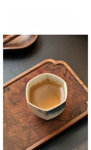 Macro view of blue glaze hexagonal ceramic teacup with golden koi fish hand-painted detail