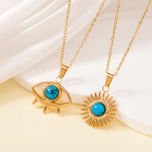 Close-up of gold stainless steel sun and eye necklaces with blue turquoise inlays