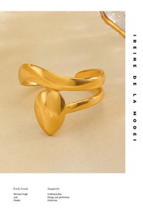 Detail of 18K gold-plated open ring featuring a teardrop design on beige silk fabric