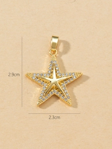 Macro shot showing dimensions 2.9cm x 2.3cm of a gold star pendant with cubic zirconia