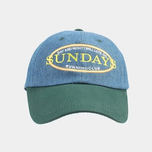 Close-up of yellow Sundays embroidery and blue denim patchwork on retro baseball cap