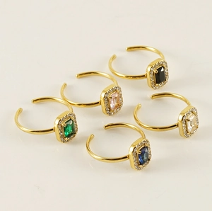 Detailed view of five adjustable gold rings with colorful square zircon gemstones
