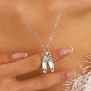 Close-up of ballet slipper pendant with pink gems on a delicate silver necklace