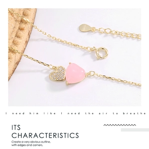 Close-up of double heart necklace featuring pink gemstone and shimmering zircon details