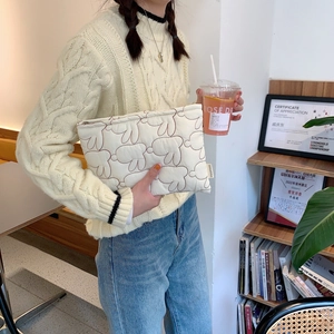 Close-up of a white quilted rabbit makeup bag with a soft texture and zipper detail