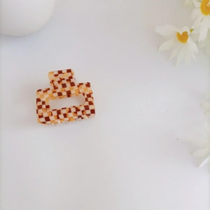Detail of checkered acrylic hair claw clip with vintage brown and beige pattern