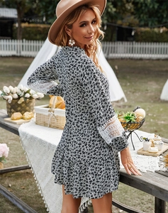 Detail of elegant black floral dress featuring delicate white lace stitching on cuffs