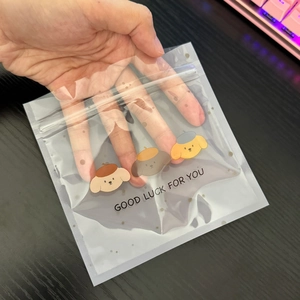 Handheld view showing size of cute cartoon dog pattern plastic self-sealing bag
