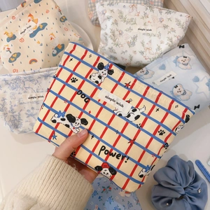 Close-up of cotton cosmetic bags featuring cartoon prints and simple wish woven labels