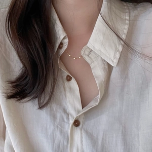 Minimalist cream long sleeve linen shirt with classic collar and brown wooden buttons