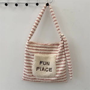 Détail du sac bandoulière rayé rose et blanc avec poche avant en peluche et boucle réglable