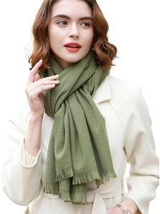 Close-up of olive green cashmere-like shawl featuring soft texture and tassel hem details