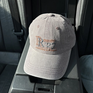 Detail of vintage washed cotton baseball cap with R27 letter embroidery and stitching
