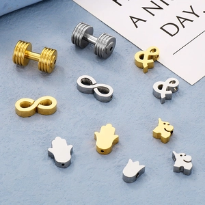 Detailed view of assorted gold and silver metal charms like elephant and hamsa symbols
