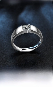Macro shot of a polished silver men's ring with a tension-set round moissanite gemstone