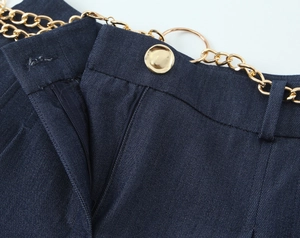Détail du short décontracté bleu foncé avec boucle en métal doré et chaîne de taille