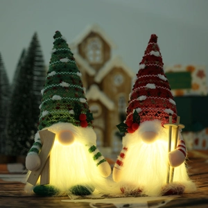Pair of glowing Christmas gnomes with LED lights, knitted hats and wooden skis for decor