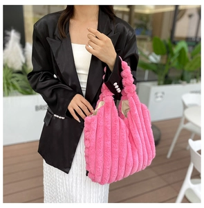 Close-up of pink faux fur tote bag with vertical stripes shown in street style scene
