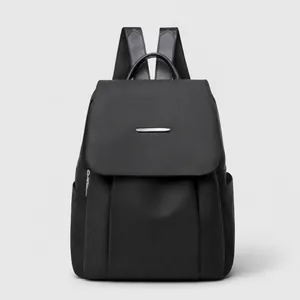 Detailansicht eines schwarzen Nylon Rucksacks mit wasserfester Textur und Metallschnalle