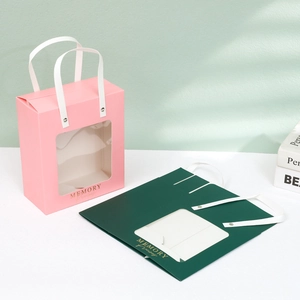 Pink and green paper gift bags with clear window and white handles for flower gifts