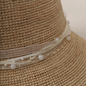 French straw sun hat with elegant lace ribbon and white pearls decoration for summer beach