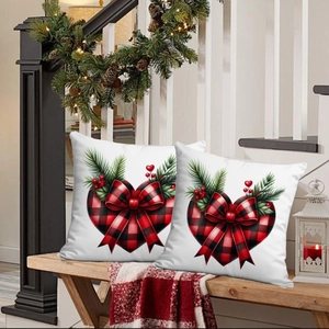 Détail de housses de coussin de Noël avec motif cœur à carreaux rouges et noirs et nœud