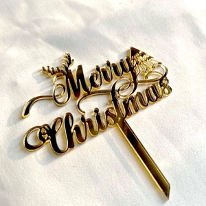 Golden acrylic Merry Christmas cake topper with reindeer antlers and festive tree motifs