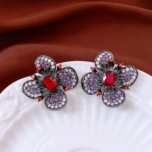 Vue détaillée de boucles d'oreilles fleurs vintage avec pierre rouge sur céramique